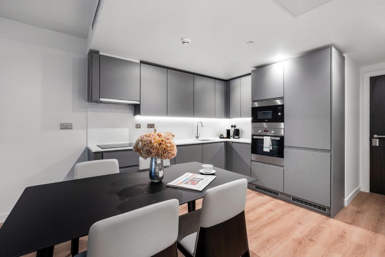 Citysuites 2 Aparthotel Селфорд Екстер'єр фото The photo shows a modern kitchen space. It features sleek, gray cabinetry with a minimalist design. There is a countertop with a sink, and appliances including an oven and a coffee maker. A dining table is positioned near the kitchen area, accompanie